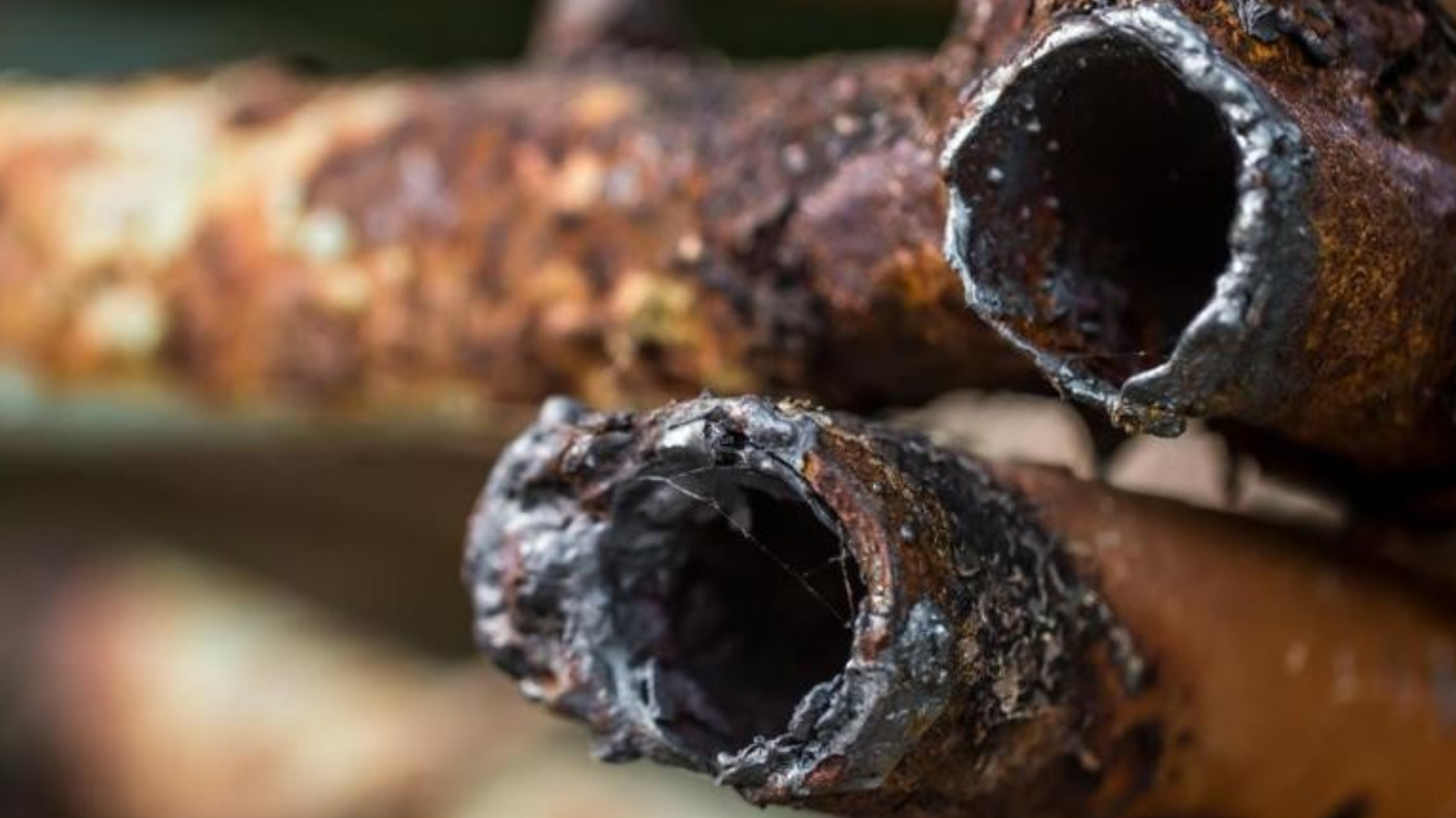 Tubulação industrial com incrustações de depósitos calcários causadas pela dureza da água.