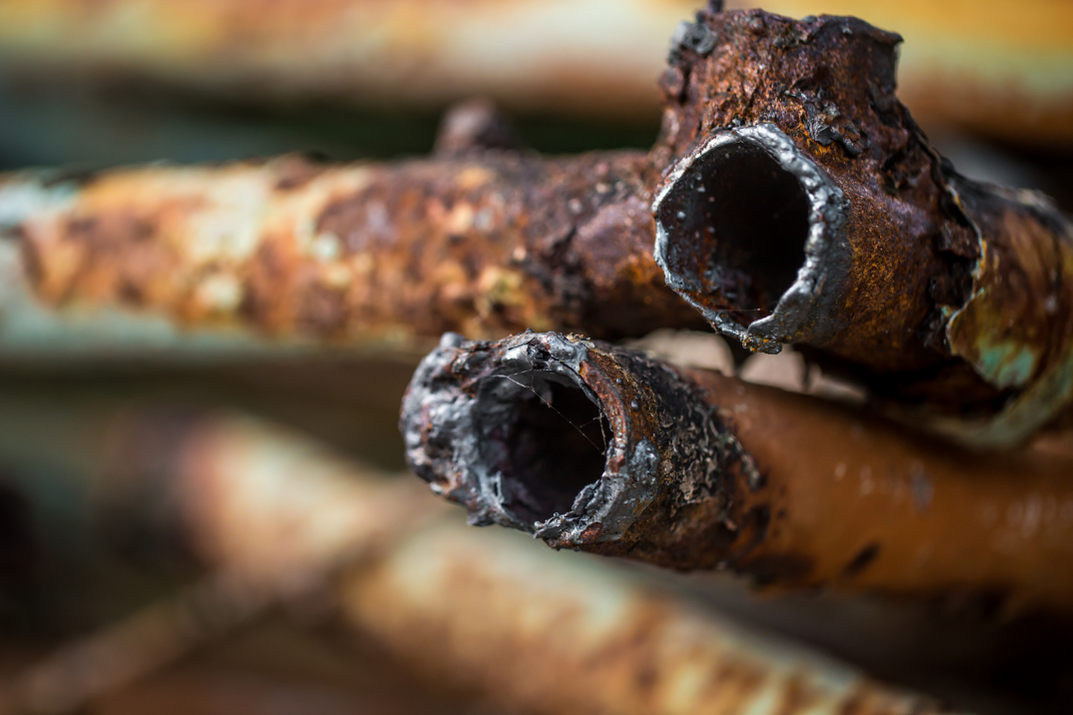 Tubulação industrial corroída com sinais de biofilme, ilustrando os impactos da corrosão em sistemas de água industrial e a necessidade de soluções como o GR Ortophos5000